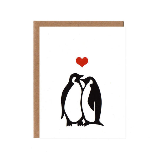 Two penguins snuggle on a white card with a heart above them
